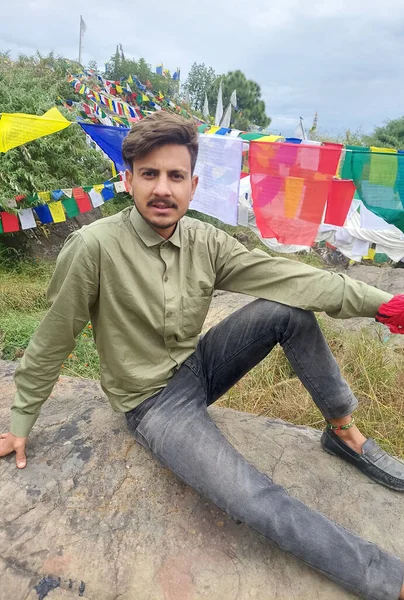 Handsome Young Guy Looking Camera While Sitting Rock Background Tibetan — Fotografia de Stock