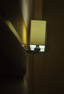 Side view of wall light lamp near to bed  in the night