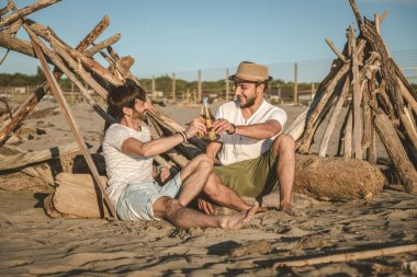 İki genç arkadaş birlikte kumsalda oturup bira içerek ve yaz günbatımında tatilde kadeh kaldırarak vakit geçiriyorlar. Arkadaşlık kavramı