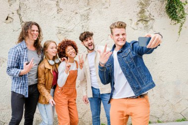 Şehirde selfie çeken mutlu gençler - Çok ırklı arkadaş grubu kameraya bakarak fotoğraf çekiyor
