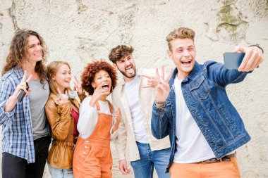 Şehirde selfie çeken mutlu gençler - Çok ırklı arkadaş grubu kameraya bakarak fotoğraf çekiyor