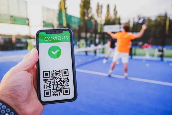 Man showing vaccination certificate covid-19 with app on smartphone first to do sport, coronavirus concept