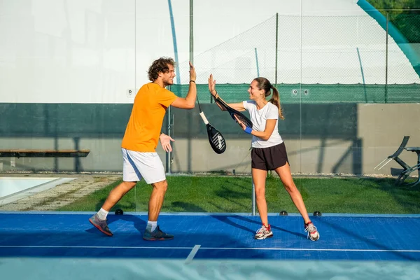 İki padel tenisçinin el sıkışması portresi