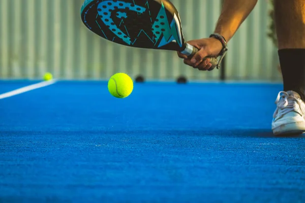 Genç bir raket tenisçisi raketle topu yakalıyor - Sporcu padel oyunu oynuyor