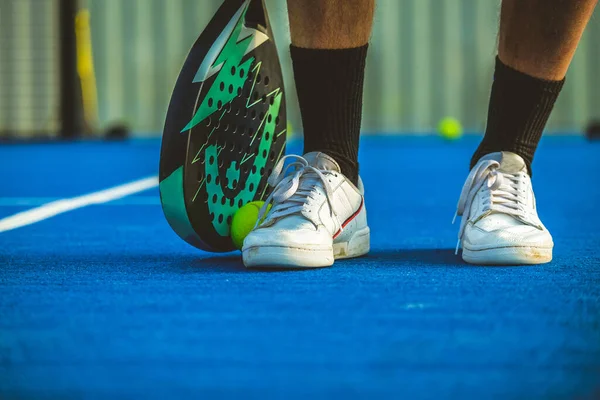 Genç bir raket tenisçisi raketle topu yakalıyor - Sporcu padel oyunu oynuyor