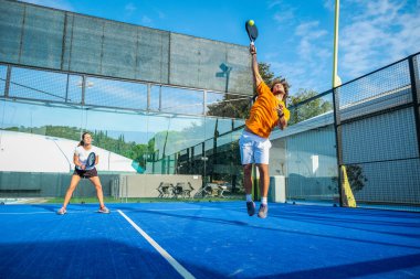 Mavi çim padel kortunda karışık padel eşleşmesi 