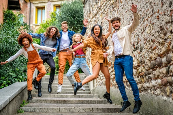 Şehir caddesinde merdivenlerden atlayan ve şehir konsepti ile eğlenen çok ırklı bir grup çılgın genç.