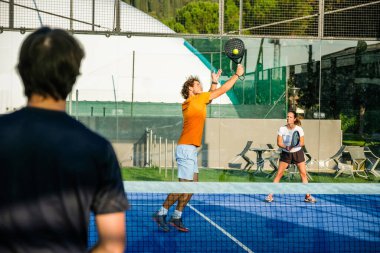 Mavi çim padel kortunda karışık padel eşleşmesi -
