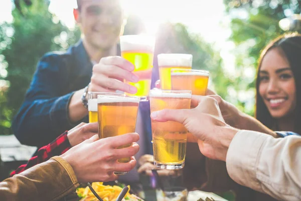 Açık bar restoranında bira içen etnik çeşitliliğe sahip bir grup arkadaş teras barında içki içmekten keyif alan gençler bira içip sohbet ediyorlar.