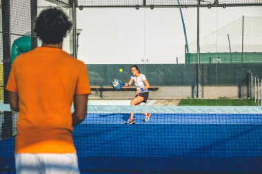 Mavi çim padel kortunda karışık padel eşleşmesi 