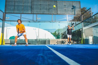 Mavi çim padel kortunda karışık padel eşleşmesi 