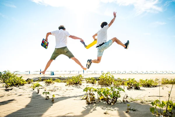 Amigos Felices Disfrutando Vacaciones Verano Playa Atardecer Dos Niños Saltando —  Fotos de Stock