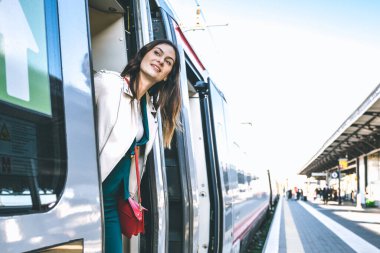 Trenin kapısında duran genç iş kadını tren istasyonunda birini arıyor güzel bir gezgin kadının trene bindiği potrait - seyahat konsepti