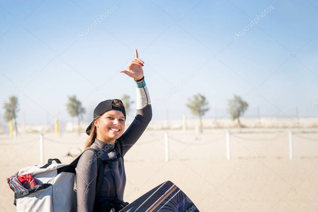 Beautiful girl smiling and comes to the beach with kitesurfing equipment - Sporty woman concept and hard sport
