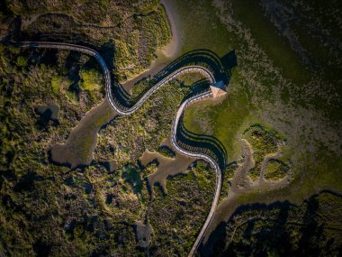 Top view of sea with wooden walkway - Aerial top view of wooden bridge pathway over marshy river with vegetation thickets, wild travel concept