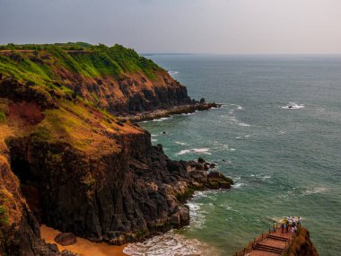 RATNAGIRI, INDIA - 19 Kasım 2021: Devghali veya Kasheli plajında keyif çatan tanımlanamayan turist, Kasheli, Ratnagiri 'de görülmeye değer manzaralar sunuyor.
