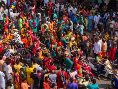 Mumbai, India - April 02, 2022: A beautiful indian females dressed in traditional attire driving a bike during a procession celebrating Gudhi Padva or Hindu new year in Mumbai