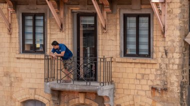 Mumbai, Hindistan - 2 Nisan 2022: Ev galerisinden Hindu Yeni Yıl geçit törenini izleyen tanımlanamayan adam.