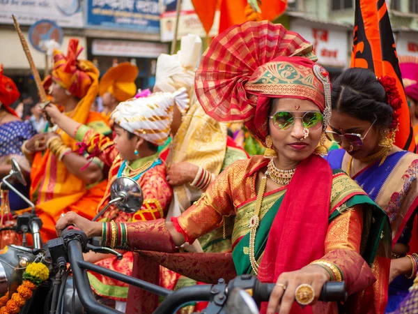2022年4月2日 ムンバイでグディ パダやヒンズー教の新年を祝う行列の間に自転車を運転する伝統的な衣装を着た美しいインドの女性 — ストック写真
