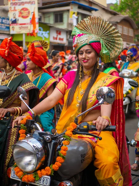 Mumbai, Hindistan - 2 Nisan 2022: Geleneksel giysiler içinde güzel bir Hintli kadın Gudhi Padva veya Hindu Yeni Yıl kutlamaları sırasında bisiklet sürüyor.