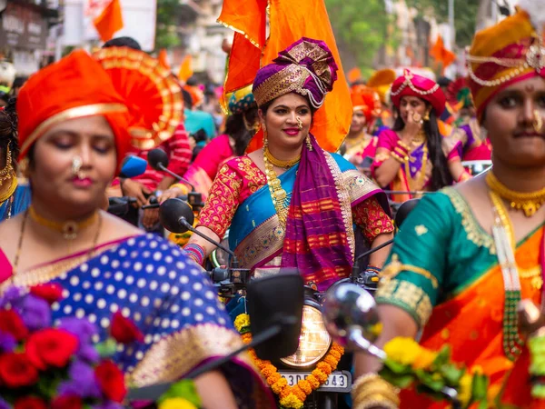 Mumbai, Hindistan - 2 Nisan 2022: Geleneksel giysiler içinde güzel bir Hintli kadın Mumbai 'de Gudhi Padva veya Hindu yeni yılını kutlarken bisiklet sürüyor.