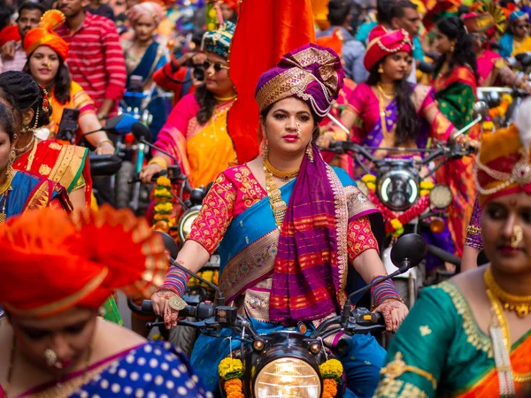 Mumbai, Hindistan - 2 Nisan 2022: Geleneksel giysiler içinde güzel bir Hintli kadın Mumbai 'de Gudhi Padva veya Hindu yeni yılını kutlarken bisiklet sürüyor.