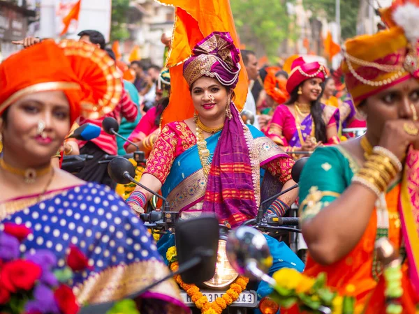 Mumbai, Hindistan - 2 Nisan 2022: Geleneksel giysiler içinde güzel bir Hintli kadın Mumbai 'de Gudhi Padva veya Hindu yeni yılını kutlarken bisiklet sürüyor.