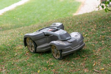Bled, Slovenya - 8 Temmuz 2021: Bir robot Husqvarna Automower çimleri biçiyor. Bahçedeki akıllı ev robotu çim biçme makinesi.