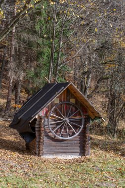 Ahırın duvarında asılı eski ahşap bir araba tekerleği..