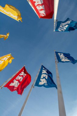 Bratislava, Slovakia - January, 2, 2022 : IKEA flags against the blue sky. IKEA has been the world's largest furniture retailer since 2008 and designs and sells ready-to-assemble furniture.