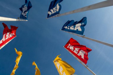 Bratislava, Slovakia - January, 2, 2022 : IKEA flags against the blue sky. IKEA has been the world's largest furniture retailer since 2008 and designs and sells ready-to-assemble furniture.
