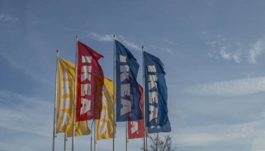 Bratislava, Slovakia - January, 2, 2022 : IKEA flags against the blue sky. IKEA has been the world's largest furniture retailer since 2008 and designs and sells ready-to-assemble furniture.