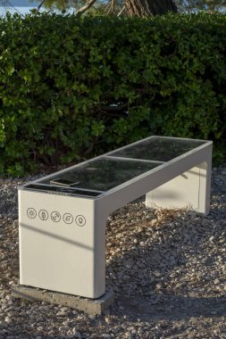 Smart Solar Bench in public place,  powered by sunlight provides wireless and wired charging for users, free wifi and temperature and weather sensors.