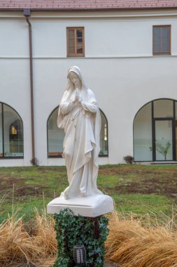 Bakire Meryem 'in beyaz heykeli manastırın arka bahçesinde dua ediyor..