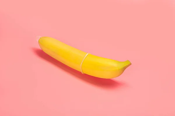 Preservativo Esticado Sobre Uma Banana Repousa Sobre Fundo Rosa — Fotografia de Stock