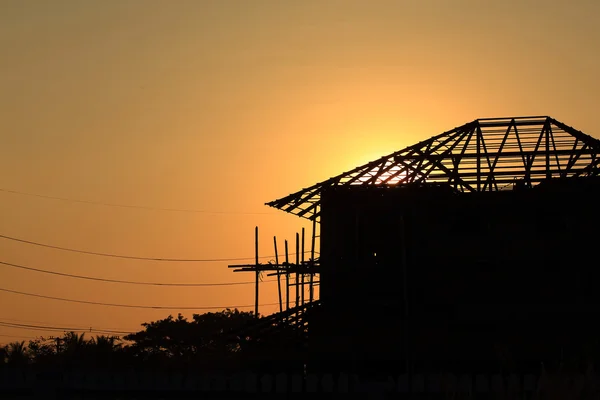 Bouwplaats silhouet, bouwen huis met de zonsondergang bac — Stockfoto