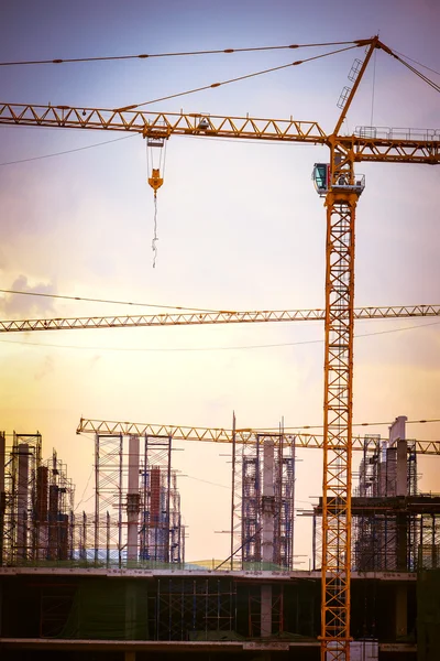 Construction site with cranes on sky, retro tone image — Stock Photo, Image