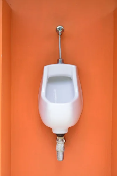 Urinoir unique sur mur orange dans les toilettes publiques — Photo