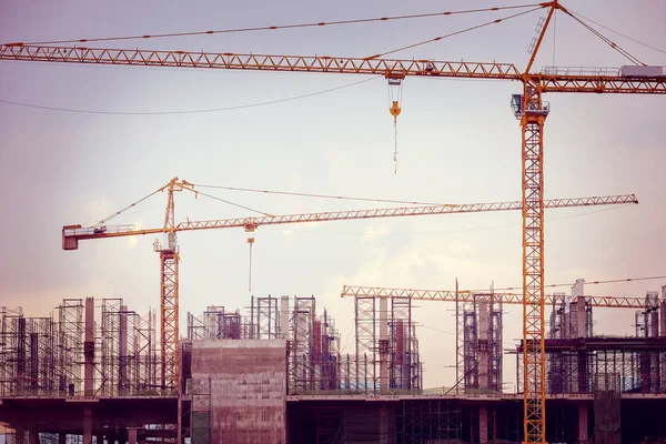 Sitio de construcción con grúas, imagen de tono retro — Foto de Stock