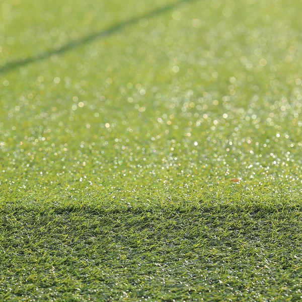 Искусственная зеленая трава и глубина боке, вне фокуса — стоковое фото