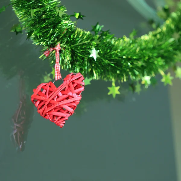 Coeur rouge suspendu sur fond de verre Photo De Stock