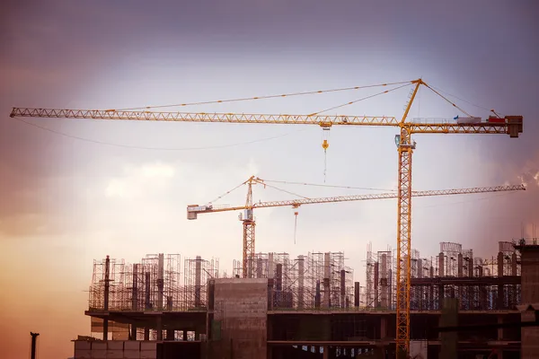 Local de construção com guindastes no fundo do céu — Fotografia de Stock