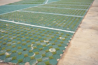 tuğla blok ve yeşil yapılmış araba park yerinde boş alan