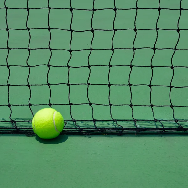 Yeşil eski kortunda tenis topu — Stok fotoğraf