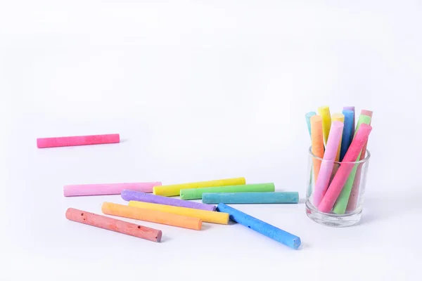 Rainbow colored chalk arranged on a white background — Stock Photo, Image