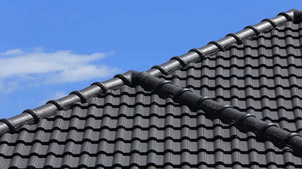 Черная черепица на крыше нового дома с голубым небом — стоковое фото