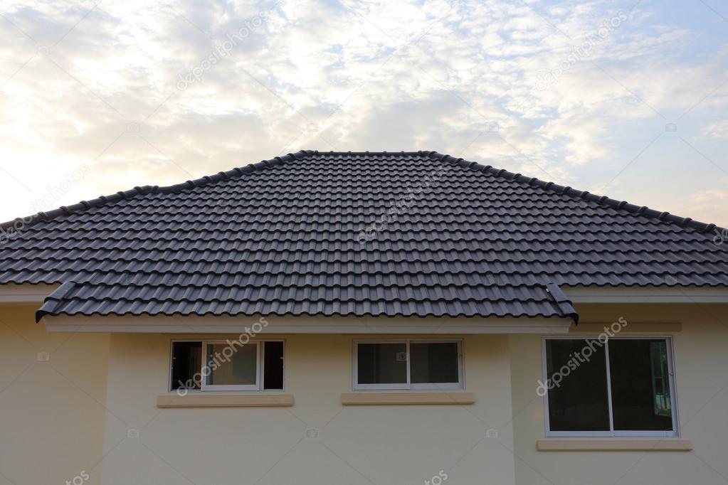 black tiles roof on a new house with sunset sky