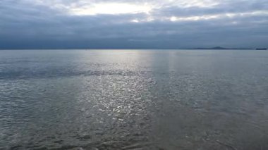 Gökyüzü ve su dalgaları üzerinde hareket eden bulutlu deniz manzarası