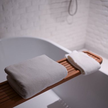 Banyoda küvete beyaz havlular konuldu.