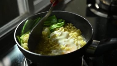 Yavaş çekim sahnesi, hazır şehriye sıcak tencerede yumurta ile pişirilen kolay yemek.